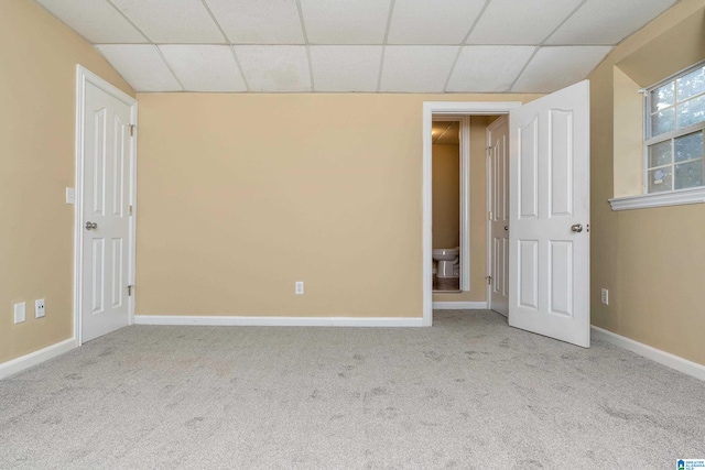 carpeted spare room with a drop ceiling