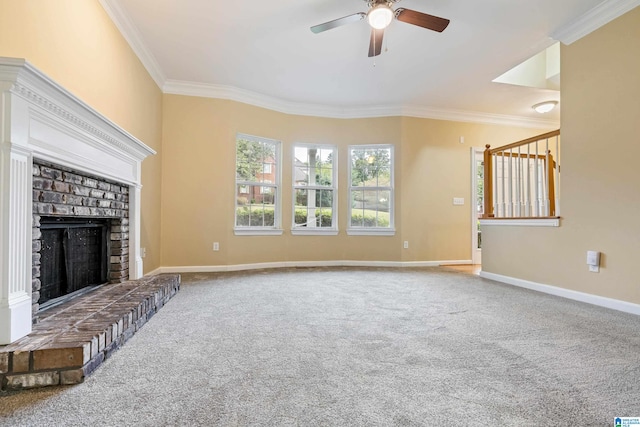 unfurnished living room featuring carpet, ceiling fan, a fireplace, and crown molding