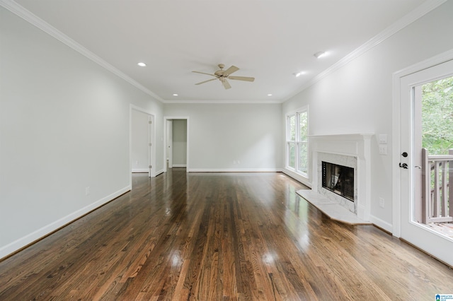 unfurnished living room featuring ceiling fan, a premium fireplace, ornamental molding, and wood-type flooring