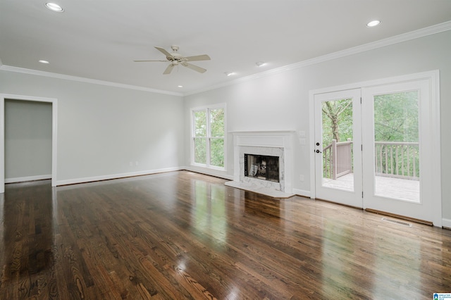 unfurnished living room with crown molding, ceiling fan, a high end fireplace, and dark hardwood / wood-style flooring