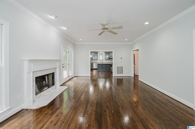 unfurnished living room featuring crown molding, a fireplace, dark hardwood / wood-style floors, and ceiling fan