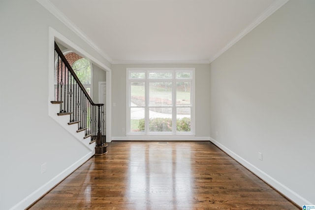 foyer entrance with ornamental molding and dark wood-type flooring