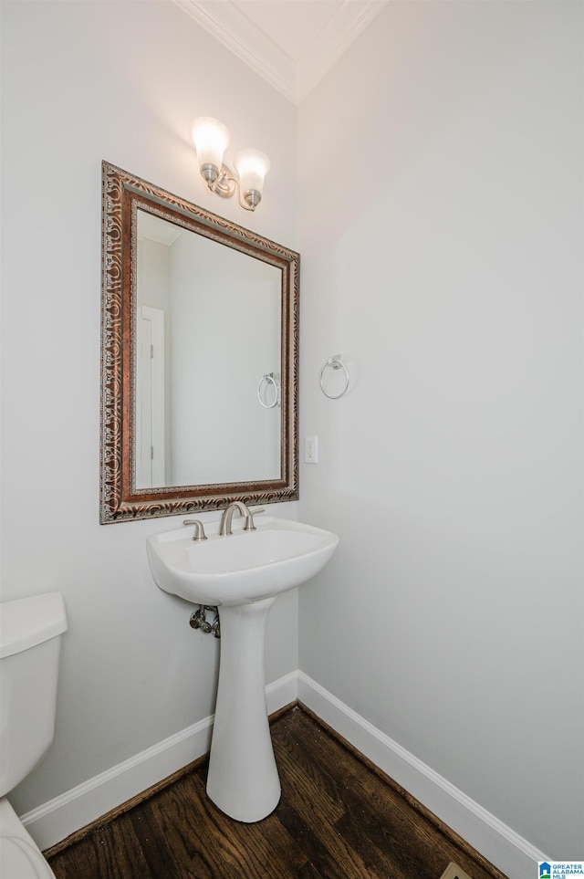 bathroom featuring ornamental molding, toilet, and hardwood / wood-style flooring