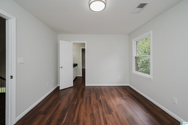 unfurnished bedroom with dark hardwood / wood-style flooring