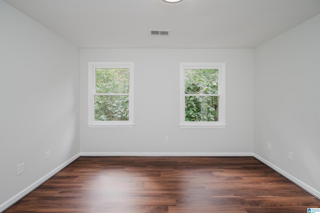 unfurnished room with dark hardwood / wood-style flooring and a wealth of natural light