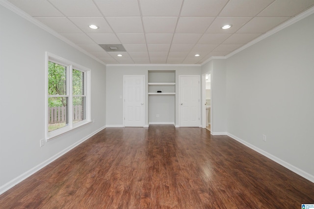 empty room with ornamental molding and dark hardwood / wood-style floors