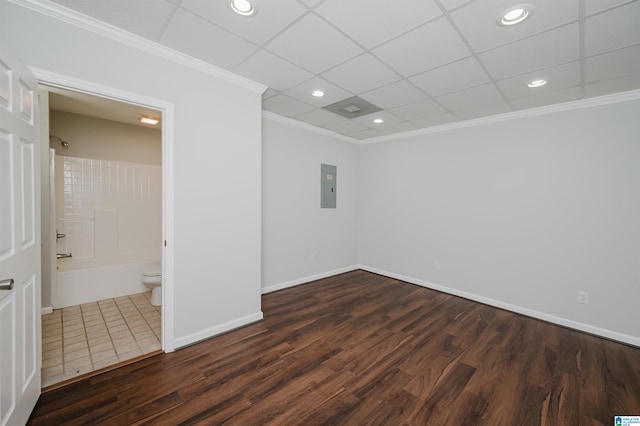 spare room featuring crown molding, a drop ceiling, dark hardwood / wood-style floors, and electric panel