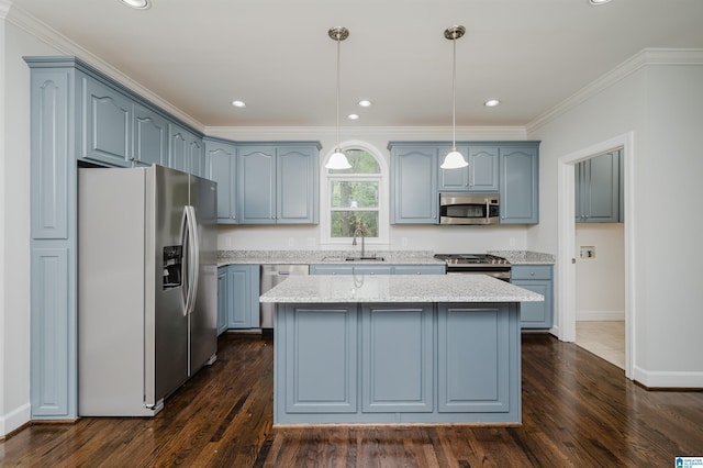 kitchen featuring appliances with stainless steel finishes, a center island, dark hardwood / wood-style floors, and pendant lighting