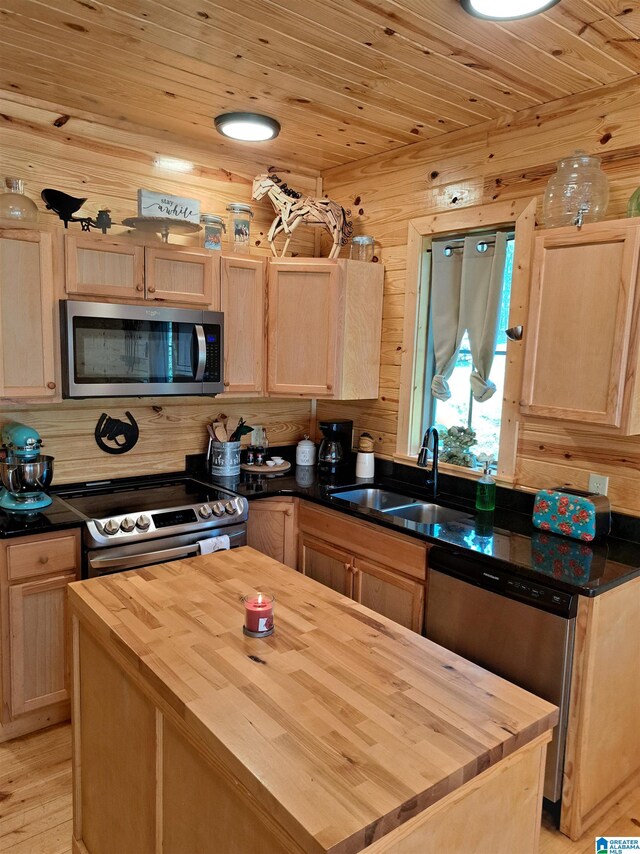 kitchen featuring appliances with stainless steel finishes, light brown cabinets, and wooden counters