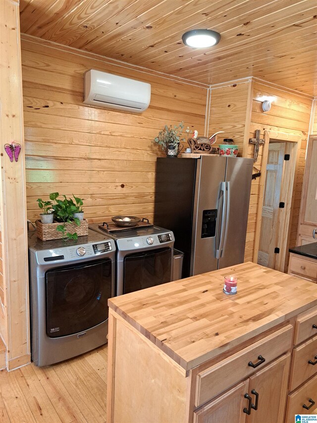 kitchen with light hardwood / wood-style floors, washing machine and clothes dryer, light brown cabinets, stainless steel refrigerator with ice dispenser, and a wall mounted AC