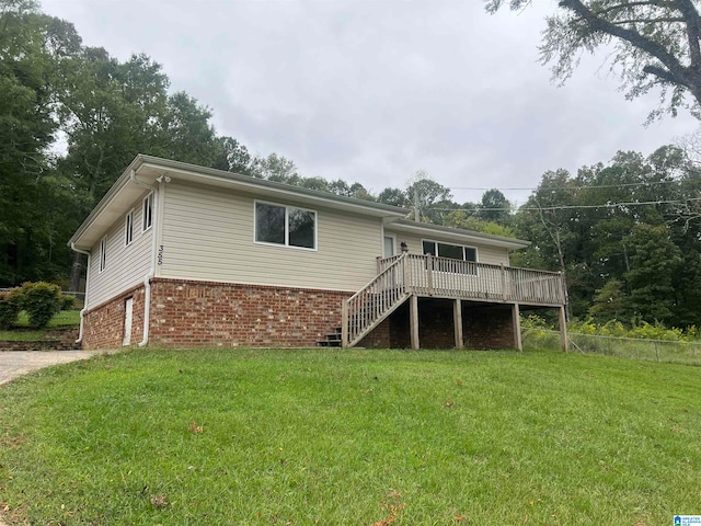 rear view of house with a wooden deck and a yard