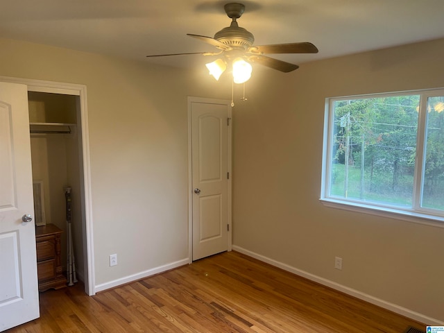 unfurnished bedroom featuring light hardwood / wood-style floors, ceiling fan, and a closet