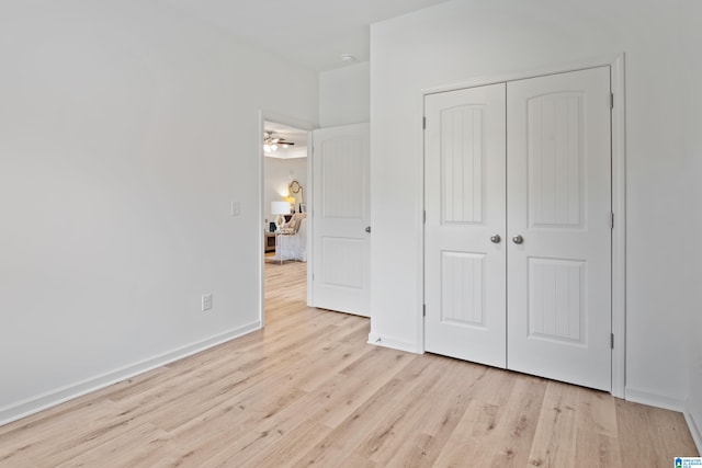 unfurnished bedroom with light hardwood / wood-style flooring and a closet