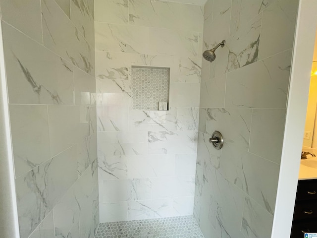 bathroom featuring tiled shower and vanity