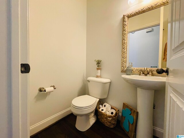 bathroom with hardwood / wood-style flooring and toilet