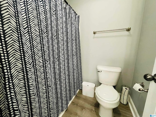 bathroom featuring hardwood / wood-style flooring, toilet, and a shower with shower curtain