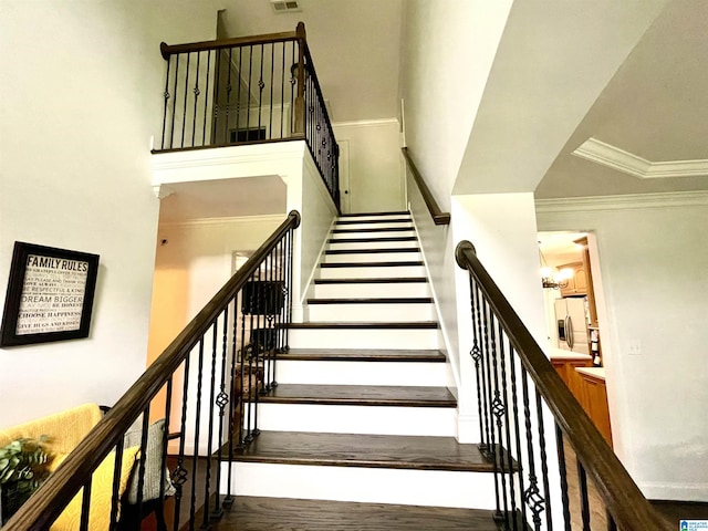 staircase featuring crown molding and hardwood / wood-style flooring