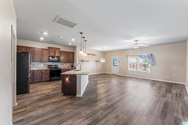 kitchen featuring ceiling fan, sink, a center island with sink, black appliances, and dark hardwood / wood-style floors