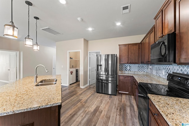 kitchen with a center island with sink, sink, dark hardwood / wood-style flooring, and black appliances