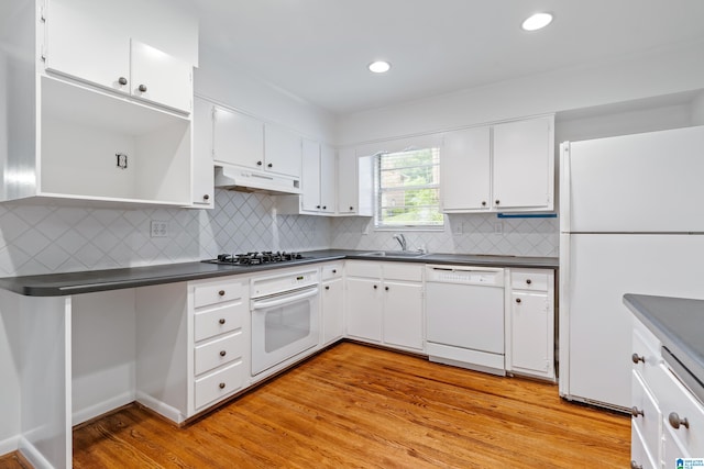 kitchen with white cabinets, sink, white appliances, backsplash, and light wood-type flooring