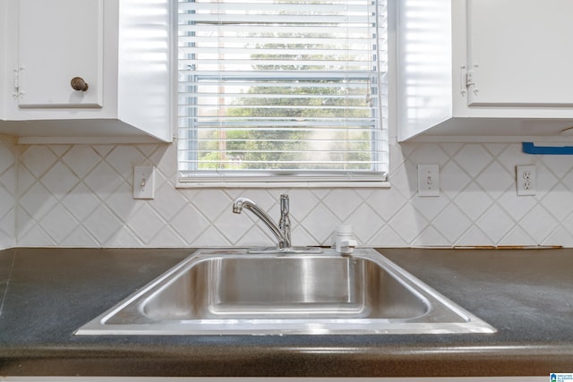 interior space with white cabinets, sink, and tasteful backsplash