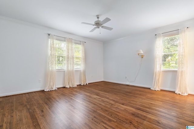 spare room with ceiling fan, ornamental molding, dark wood-type flooring, and a healthy amount of sunlight