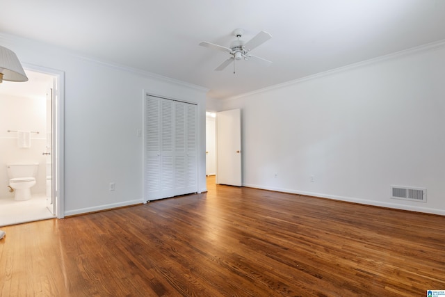 unfurnished bedroom with dark hardwood / wood-style flooring, a closet, crown molding, ceiling fan, and ensuite bathroom