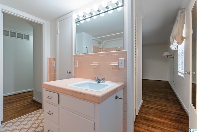 bathroom featuring tile walls, hardwood / wood-style flooring, and vanity