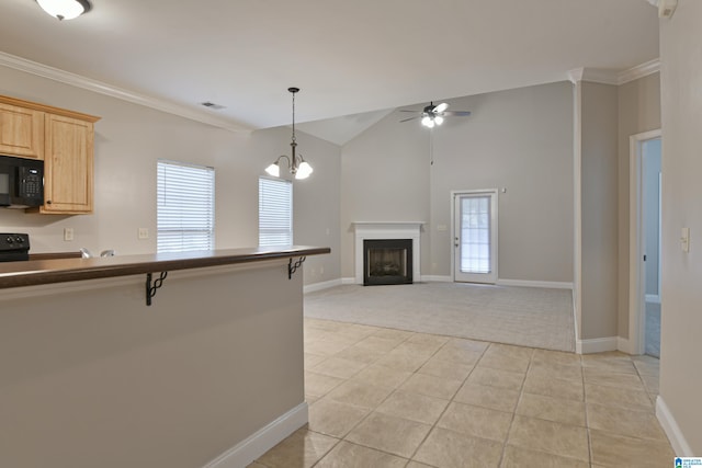 kitchen with light brown cabinets, ceiling fan with notable chandelier, crown molding, a kitchen bar, and a healthy amount of sunlight