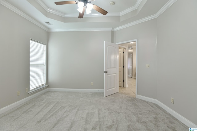 empty room with light carpet, ceiling fan, plenty of natural light, and crown molding