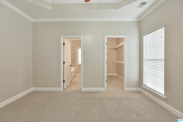 unfurnished bedroom with a spacious closet, connected bathroom, a closet, ornamental molding, and light carpet