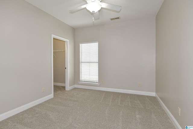 carpeted spare room featuring ceiling fan