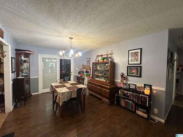 dining space featuring a notable chandelier, dark wood-type flooring, and a textured ceiling