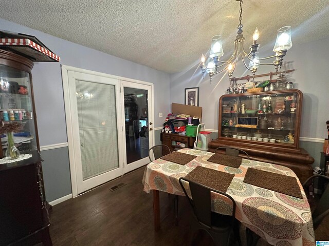 dining area featuring a notable chandelier, a textured ceiling, and dark hardwood / wood-style floors