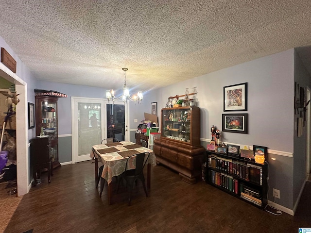 dining room with a textured ceiling, an inviting chandelier, and dark wood-type flooring