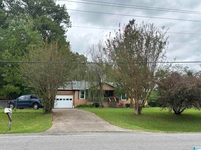 single story home featuring a garage and a front yard