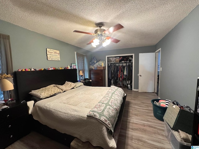 bedroom with ceiling fan, hardwood / wood-style flooring, a closet, and a textured ceiling