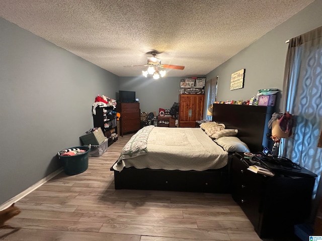 bedroom with a textured ceiling, hardwood / wood-style floors, and ceiling fan