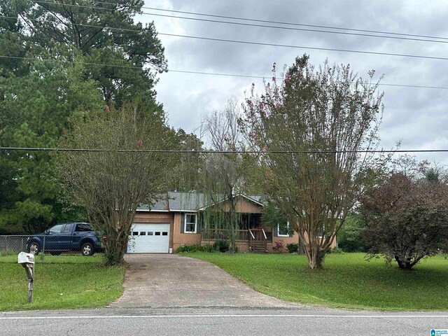 ranch-style house featuring a garage and a front yard