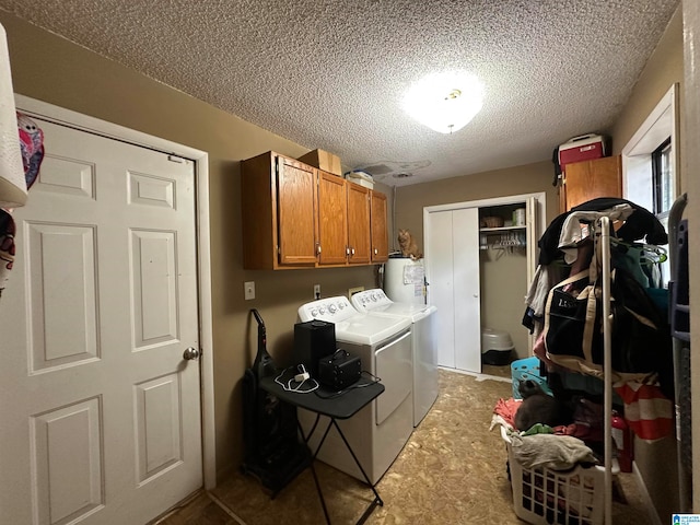 laundry room with cabinets, water heater, a textured ceiling, and independent washer and dryer