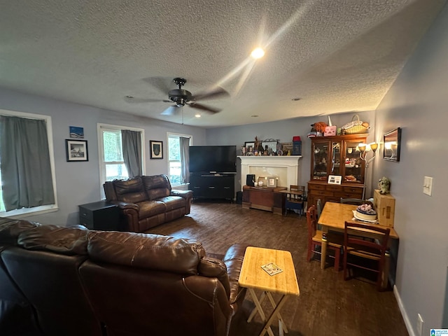 living room with ceiling fan, a textured ceiling, and dark hardwood / wood-style floors