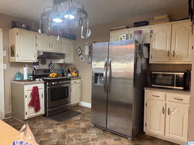 kitchen with white cabinets, a textured ceiling, and stainless steel appliances