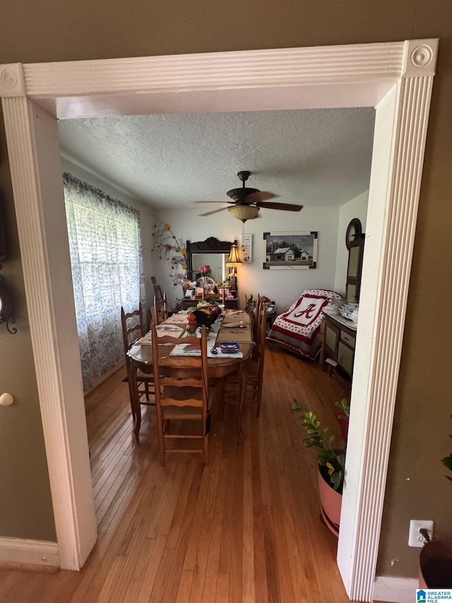 dining area featuring a textured ceiling, ceiling fan, and hardwood / wood-style flooring