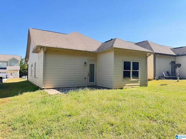 back of house with a yard and a garage