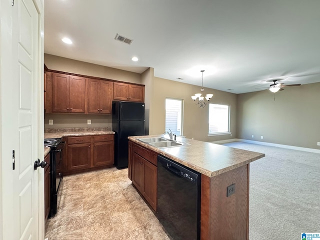 kitchen with sink, decorative light fixtures, a center island with sink, black appliances, and light colored carpet