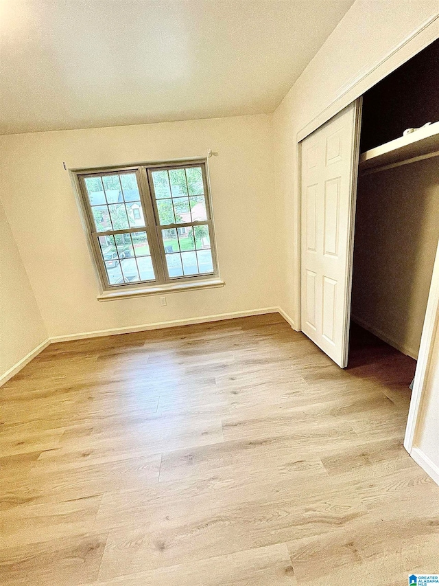 unfurnished bedroom featuring light wood-type flooring and a closet