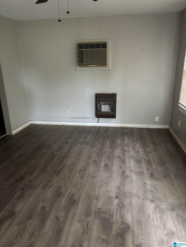 unfurnished living room featuring heating unit, ceiling fan, a wall mounted air conditioner, and hardwood / wood-style flooring