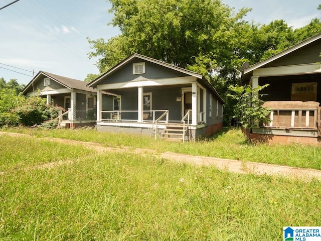 rear view of house featuring a sunroom and a lawn