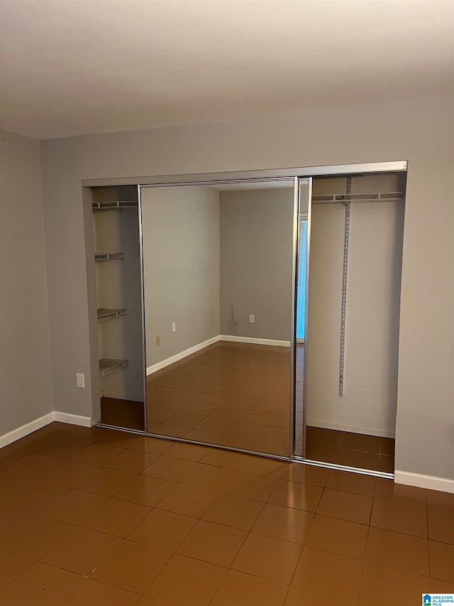 unfurnished bedroom with a closet and tile patterned floors