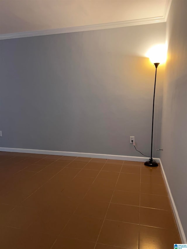 tiled empty room featuring crown molding